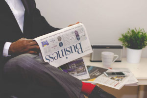 someone sitting reading a business newspaper