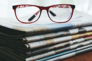 reading glasses on a stack of newspapers